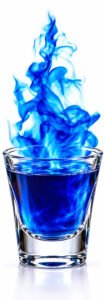 A shot glass with blue liquid and blue flames.